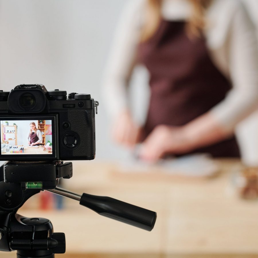 Creative young woman in home camera recording soap making master class for her subscribers